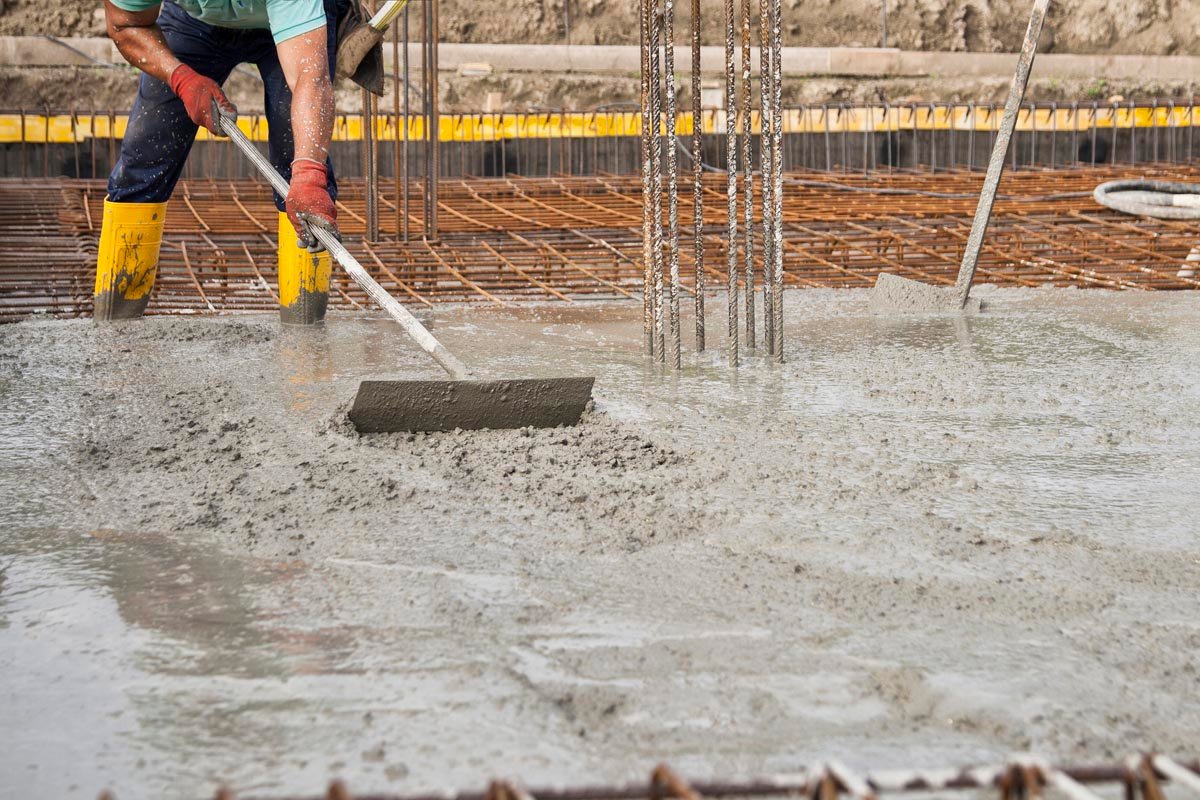 a bricklayers who level the freshly poured concrete to lay the f Jummp Marketing|Concrete